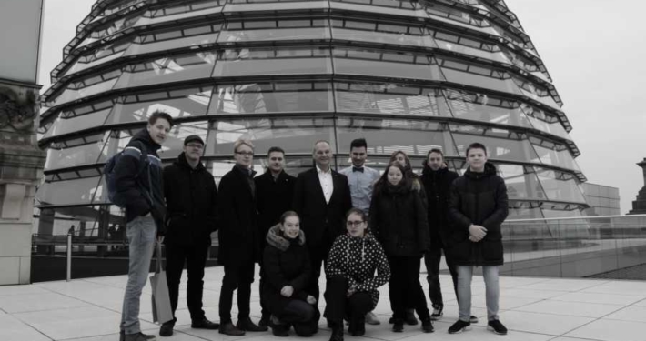 Ein Schwarz-Weiß-Foto. Mathias Stein mit den Mitgliedern des Jungen Rats Kiel 2019 vor der Reichstagskuppel
