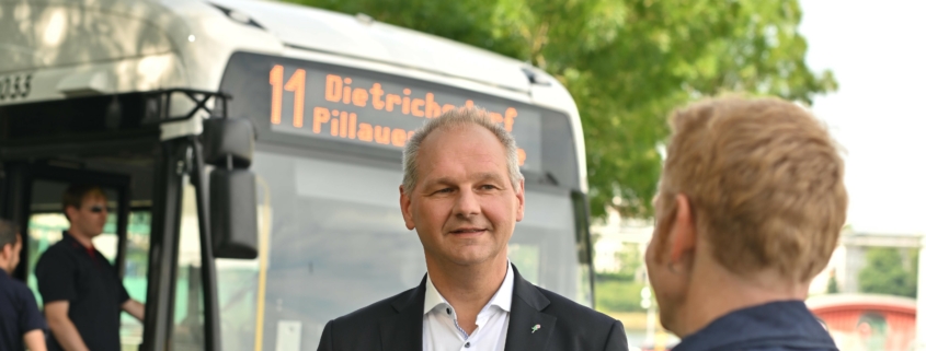 Mathias Stein im Gespräch mit einem Bürger vor einem Elektrobus § Foto: Bevis Nickel